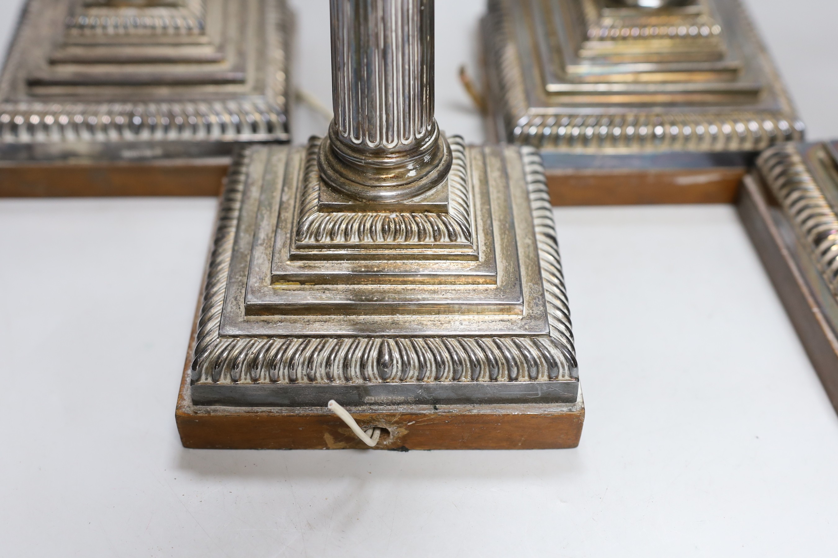 A set of four early 20th century silver plated Corinthian column table lamps on marble stands 33cms high (not including light fitting)